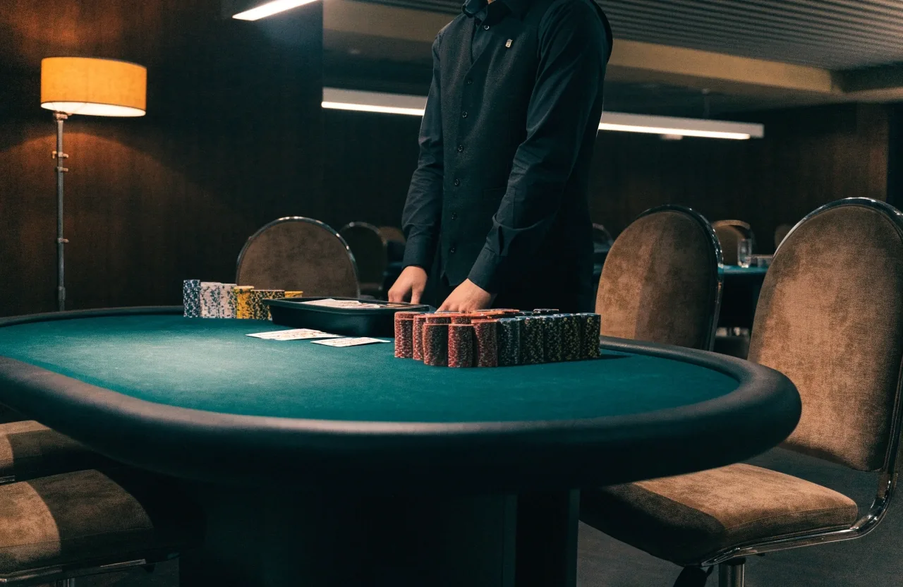 Wydzielona sala pokerowa w Château Rives z ustawionymi stolikami, tacą krupiera i stosami żetonów